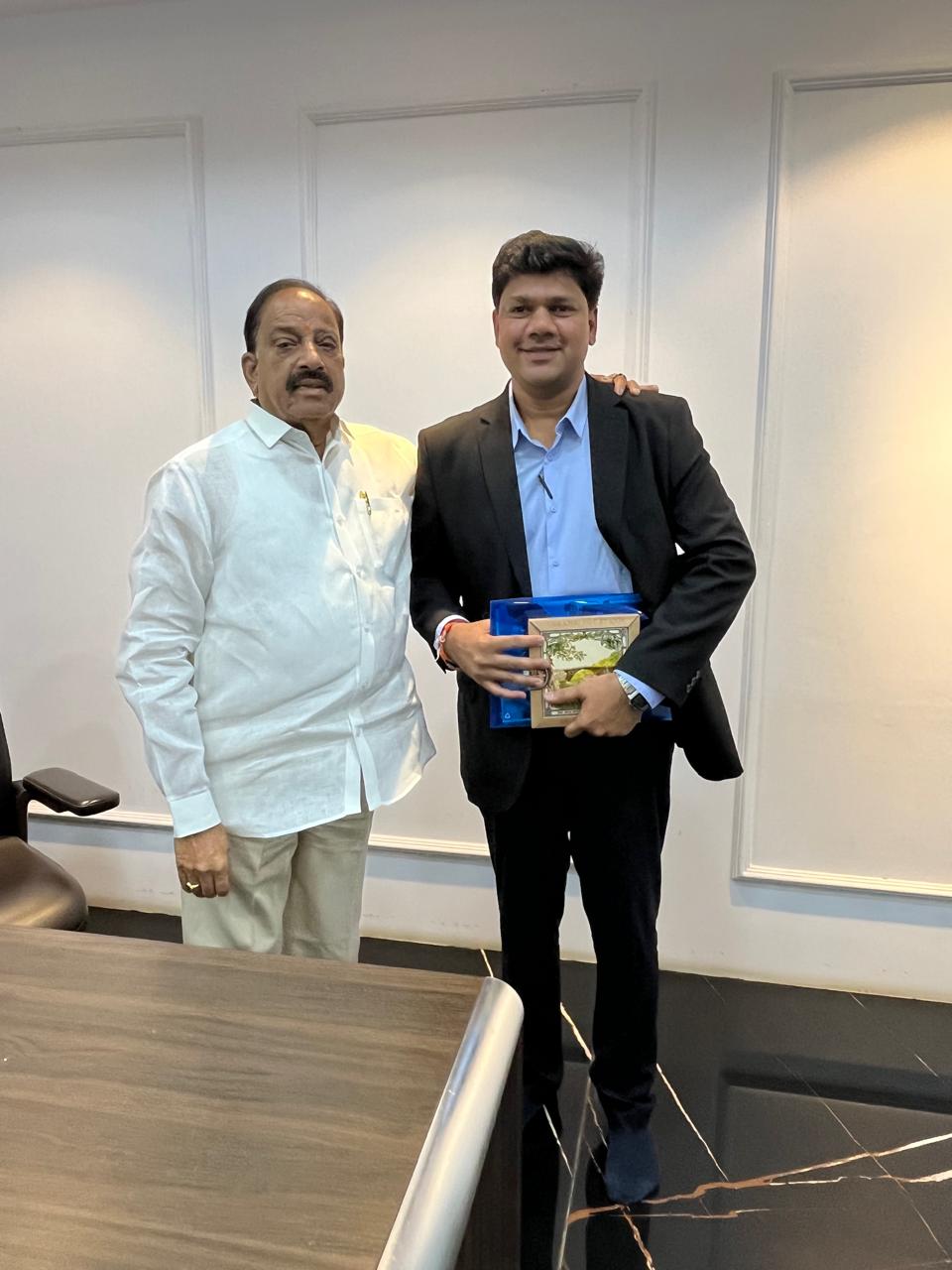 A member of the visiting group holds a framed gift beside the Agriculture Minister of Telangana